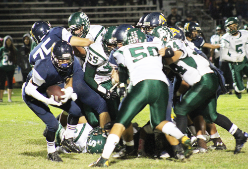 A TIGHT GRIP During the 2014 AHS Homecoming game against the Schurr Spartans, senior running back Fernando Guerrero attempts to surpass the herd of persisting opponents.